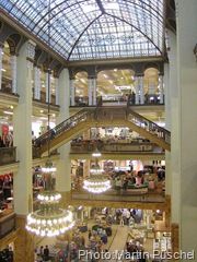 Kurz vor seiner Schließung im August 2009 gehörte das Kaufhaus zur Hertie-Gruppe. Hier sind sehr schön der beeindruckende Lichthof und das Zusammenspiel von Treppen und Galerien zu sehen.